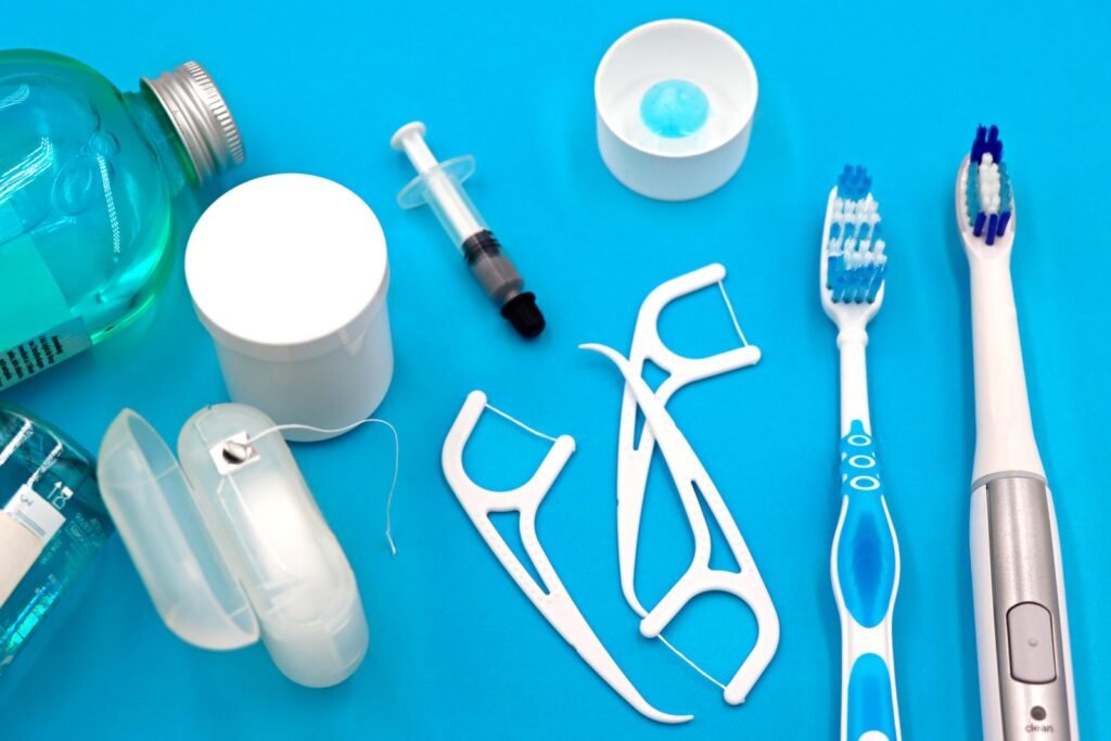 Dental floss picks, floss container, mouthwash, and toothbrushes laid out on a blue background