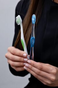 Hands holding two different toothbrushes for comparison