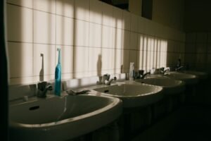 Sunlit bathroom sinks with a toothbrush and toothpaste