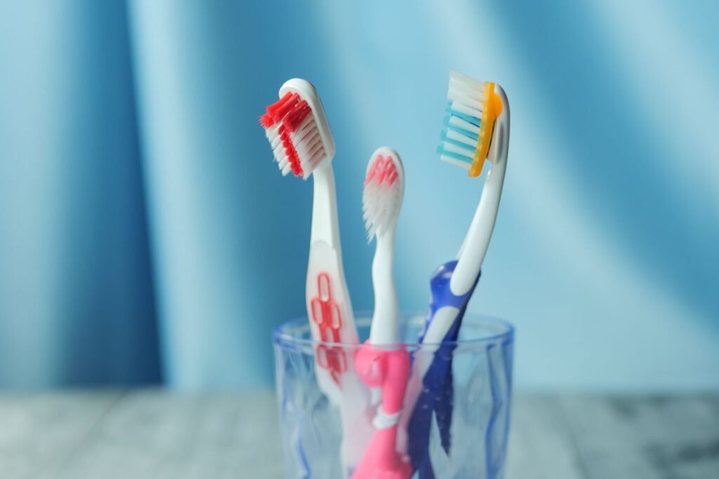 Three toothbrushes in a cup against a blue background
