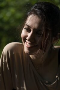 Woman smiling softly outdoors in natural light