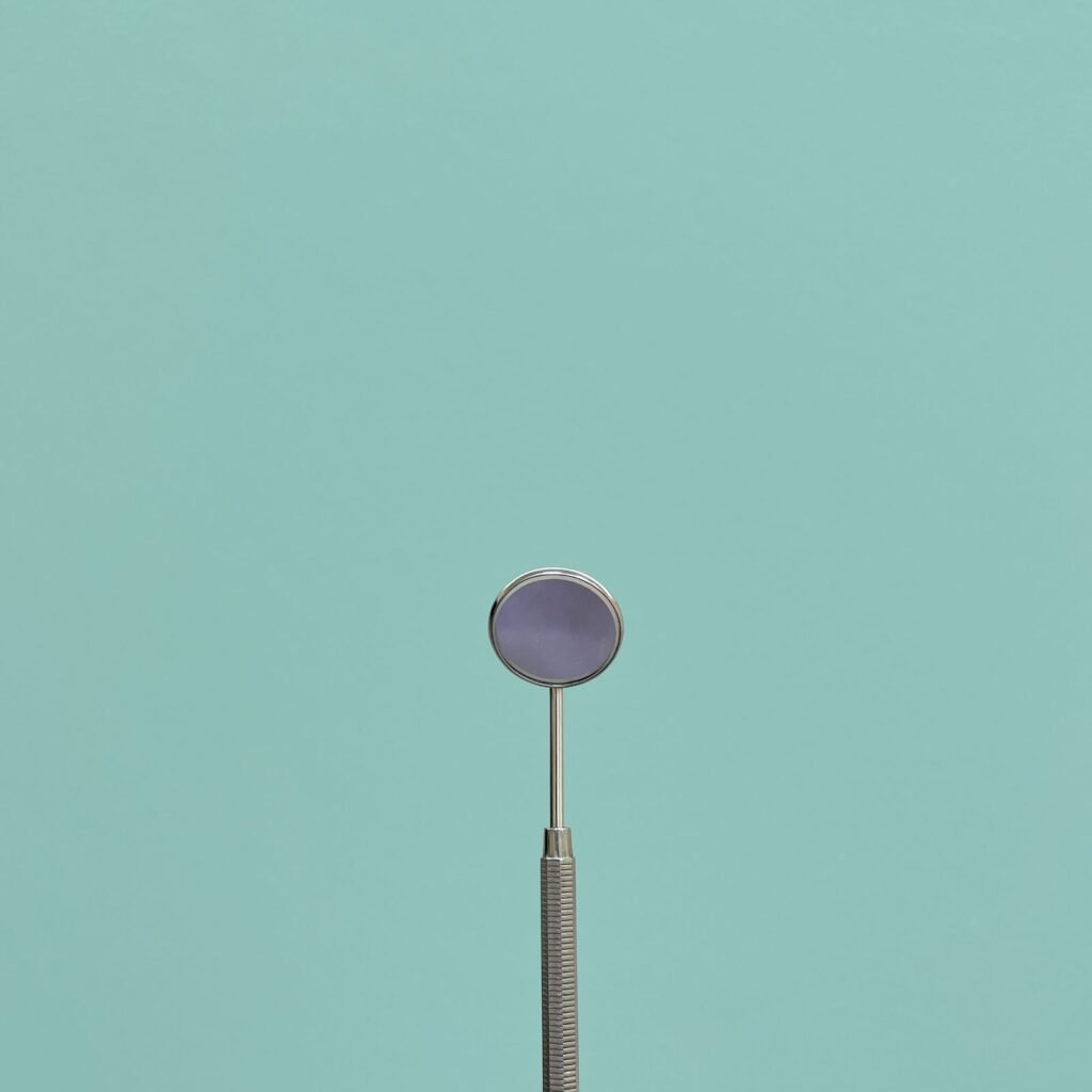 Minimalist dental tool against a teal background