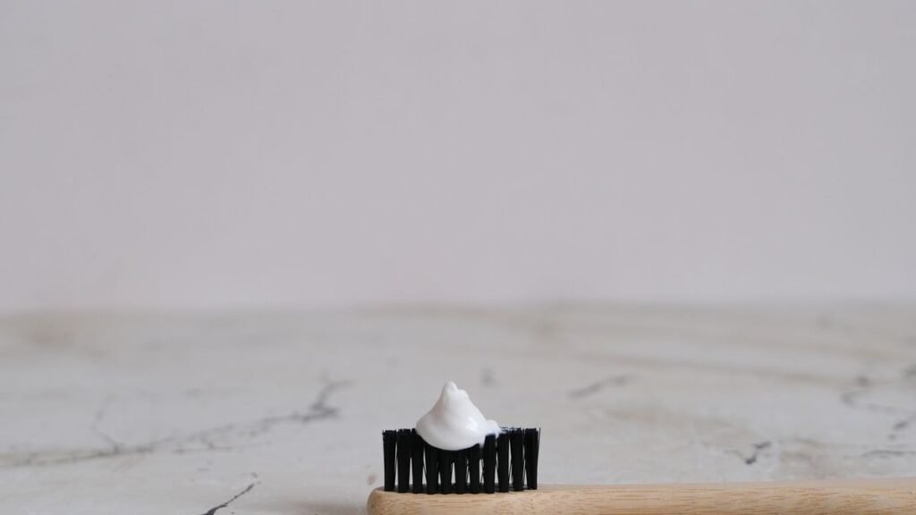 Toothbrush with a dab of white toothpaste on a bathroom counter