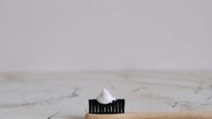 Toothbrush with a dab of white toothpaste on a bathroom counter