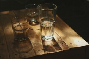 Glasses of water on a wooden table, representing hydration and dry mouth