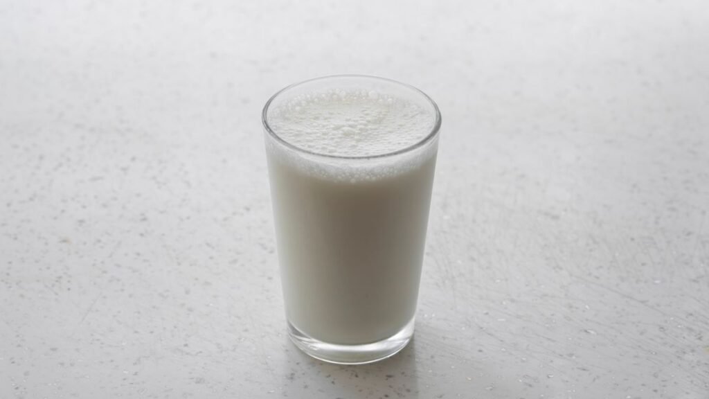 A glass of milk on a light speckled countertop