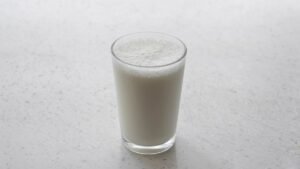 A glass of milk on a light speckled countertop