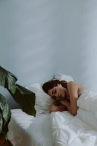 Woman sleeping peacefully in bed, representing nighttime teeth grinding and bruxism
